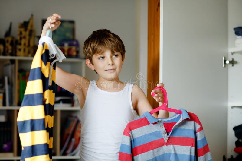 Premium Photo  Little asian boy using hanger hang up a clothes on wood rack