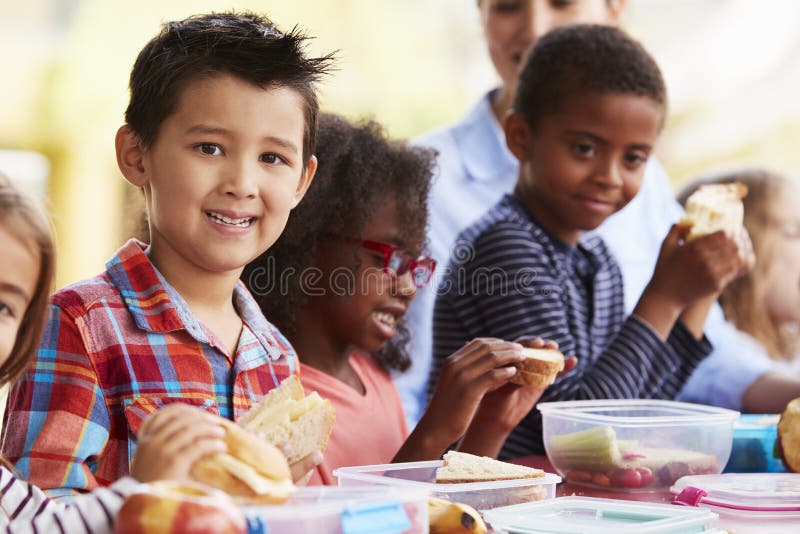 School Kids Eating Packed Lunches Together at a Table Stock Photo