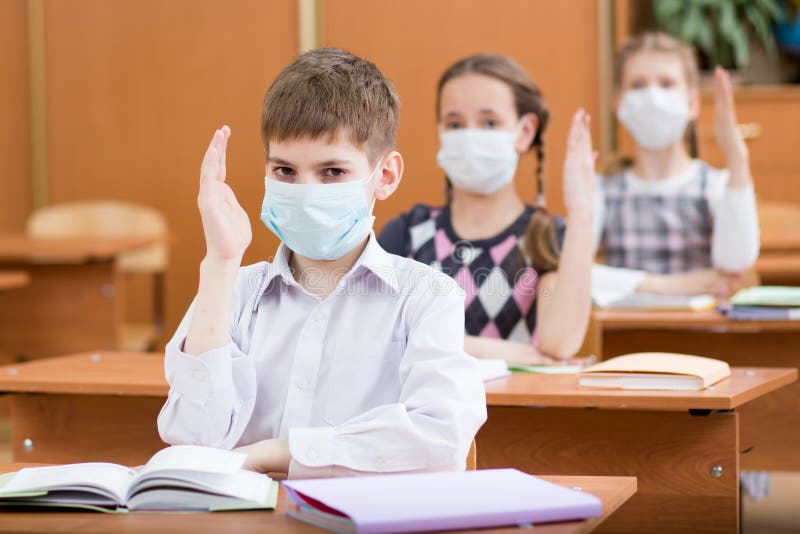School kids with protection mask against flu virus at lesson in classroom royalty free stock photo School kids with protection mask against flu virus at lesson in classroom royalty free stock photo