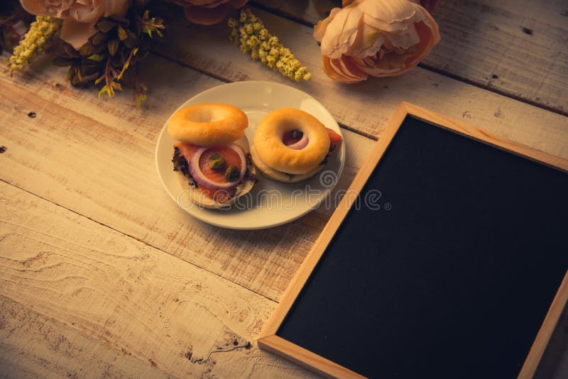School leeg houten bord op houten vloer met hamburgerbrood en droge bloemen Onderwijs en Aardconcept Terug naar School royalty-vrije stock fotografie School leeg houten bord op houten vloer met hamburgerbrood en droge bloemen Onderwijs en Aardconcept Terug naar School royalty-vrije stock fotografie