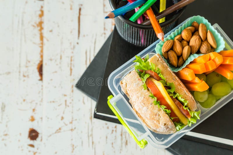 School Lunch Box with Books and Pencils in Front of Black Board Stock