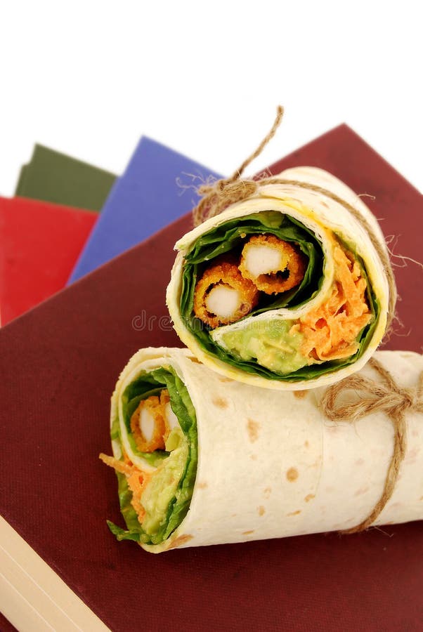 School Lunch Chicken Wrap Sandwich on Stack of Books Stock Image