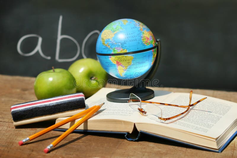 School books and apple in front of school chalkboard with small atlas. Atlas book stock images, royalty-free photos and pictures