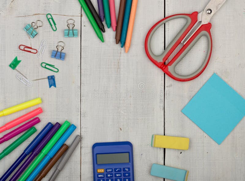 School supplies - scissors, stickers, calculator, crayons, eraser, markers and other accessories on white wooden table