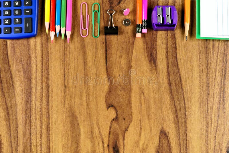 School supplies top border on wood desk background