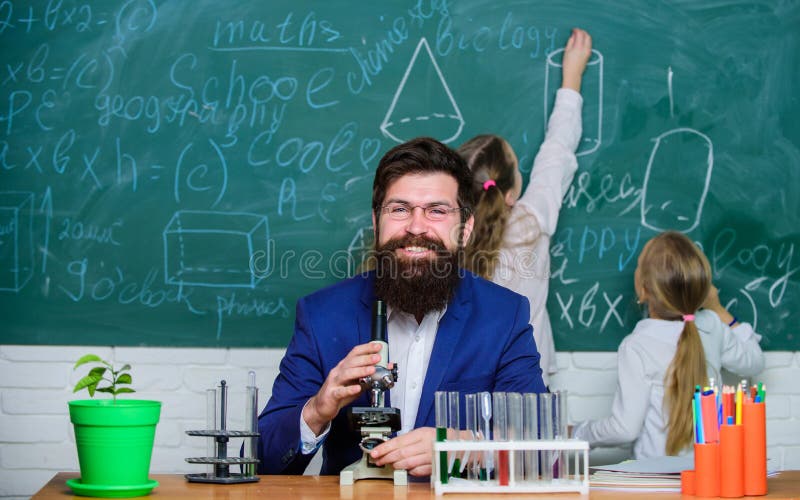School teacher of biology. Man bearded teacher work with microscope and test tubes in biology classroom. Biology plays.