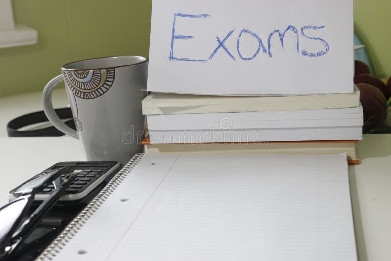 A school teachers desk with glasses and exam paper being marked on it. education, educator, teaching concept.