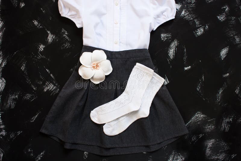 School uniform with white shirt, socks and dark denim skirt on a black background. Flatlay, top view, copy space stock photos School uniform with white shirt, socks and dark denim skirt on a black background. Flatlay, top view, copy space stock photos