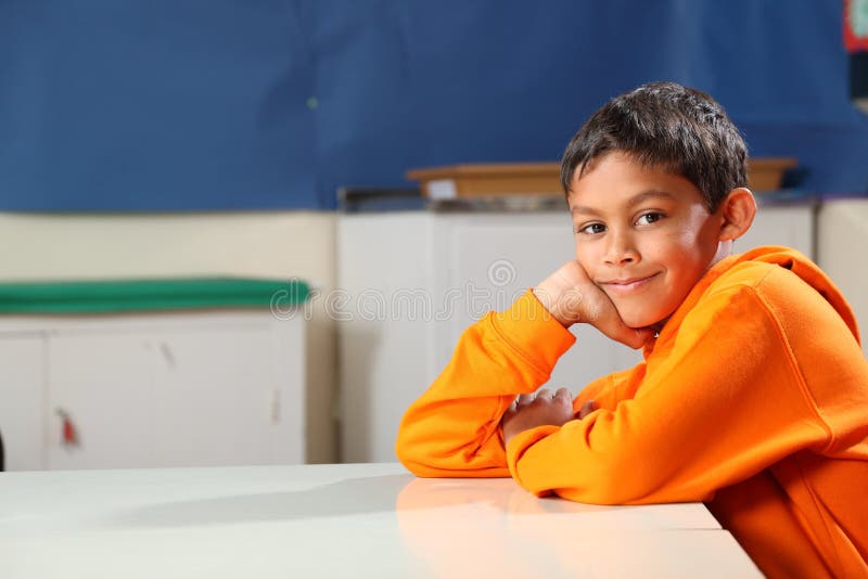 Jung junge, 10, tragen kapuzenpullover ruht sich aus auf seinem Schreibtisch.
