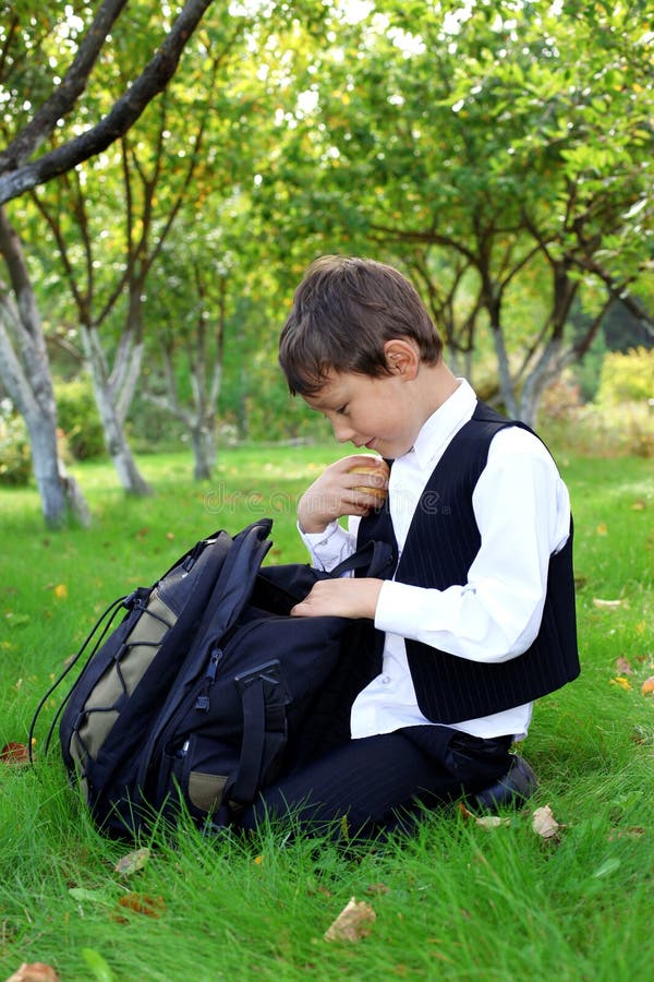 Schoolboy with apple outdoors