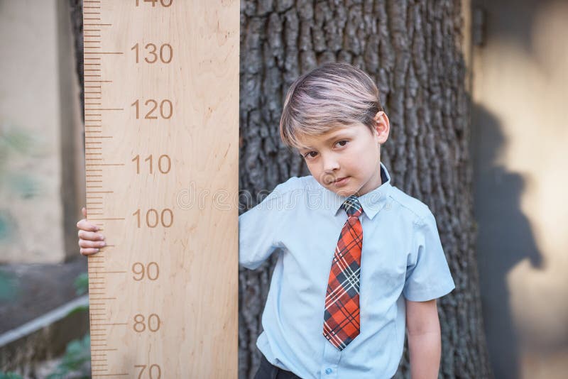 Schoolboy with big ruler standing on wooden background. Farewell Bell. day of knowledge. beginning of the school year. education a