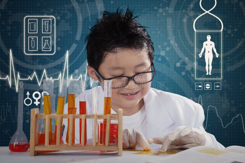 Portrait of a little schoolboy creates chemistry experiments while wearing coat and gloves in the lab. Portrait of a little schoolboy creates chemistry experiments while wearing coat and gloves in the lab