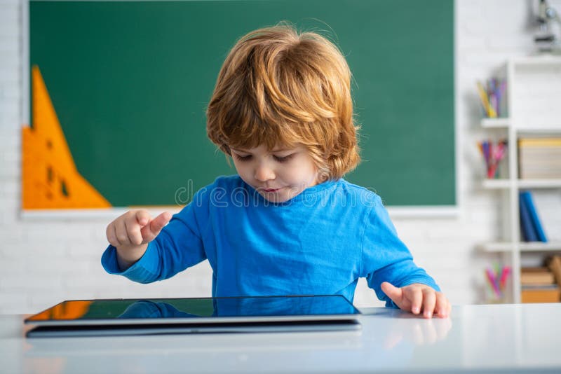 Schoolboy with digital tablet in school classroom. royalty free stock photography