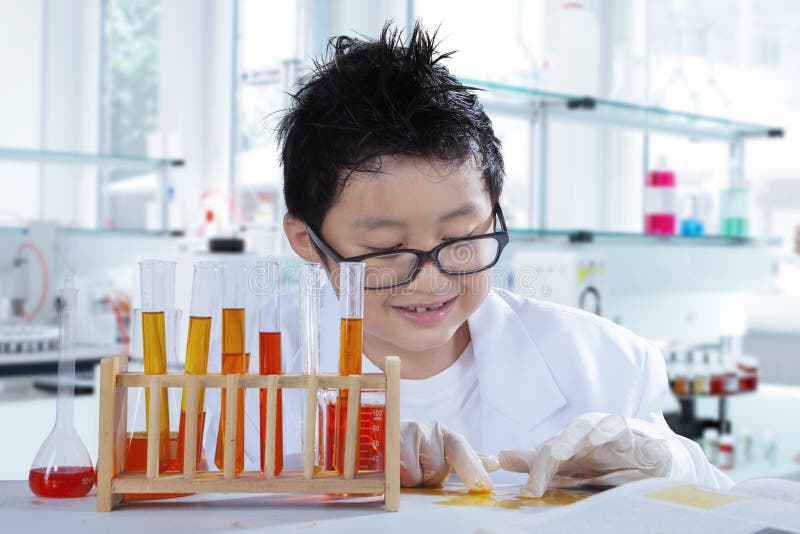 Picture of a schoolboy doing chemical experiments on the table, shot in the laboratory. Picture of a schoolboy doing chemical experiments on the table, shot in the laboratory