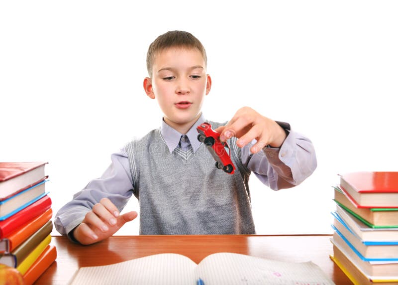 Schoolboy plays with a Toy on the School Desk on the white background. Boring kid white stock images, royalty-free photos and pictures