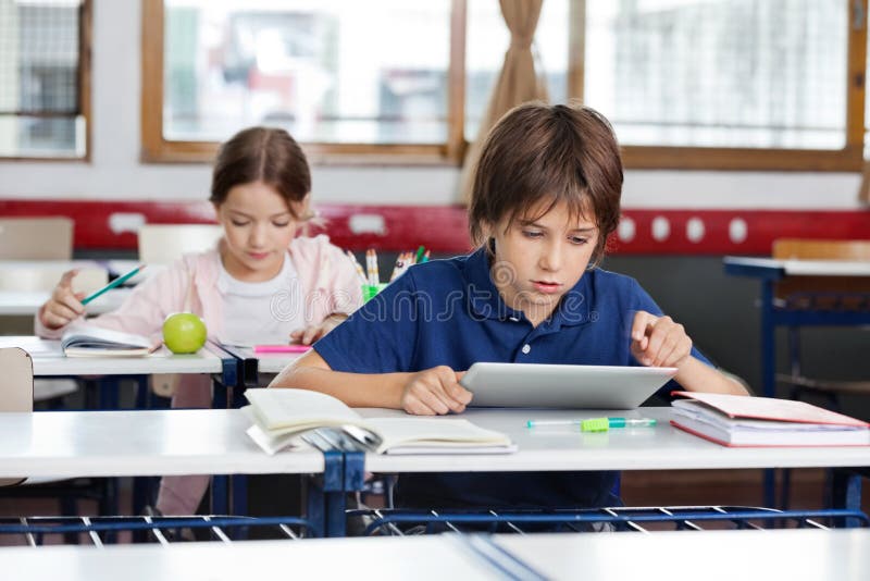 Schoolboy Using Digital Tablet In Classroom royalty free stock photography