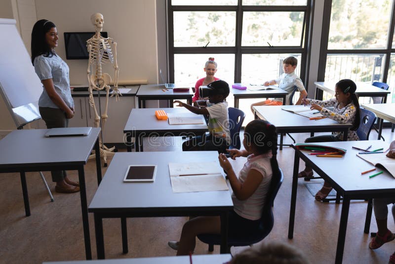 Schoolboy using virtual reality headset and his classmates and teacher looking at him royalty free stock photography Schoolboy using virtual reality headset and his classmates and teacher looking at him royalty free stock photography