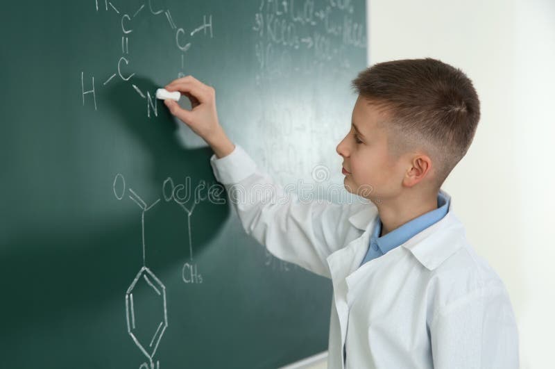 Schoolboy writing chemistry formula on blackboard royalty free stock image Schoolboy writing chemistry formula on blackboard royalty free stock image