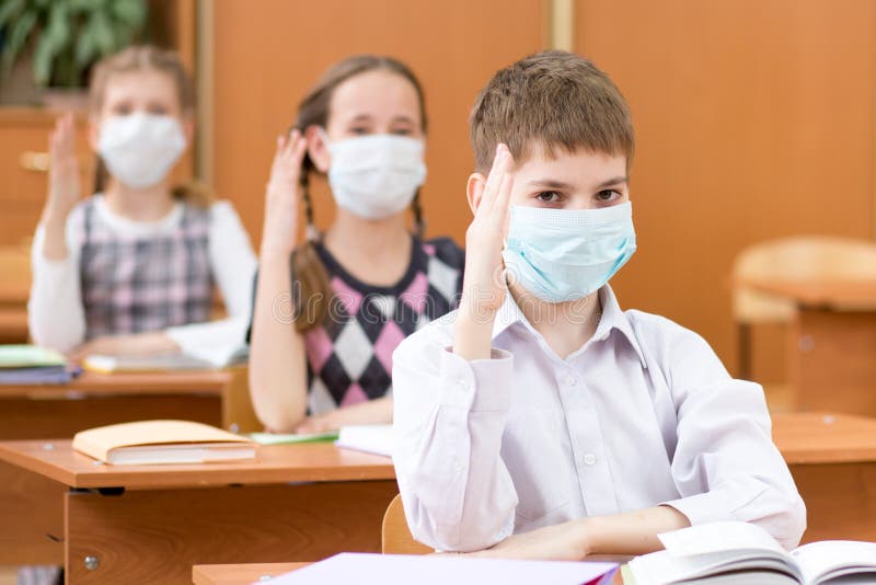 Schoolchildren with protection masks against flu virus at lesson in class stock photos Schoolchildren with protection masks against flu virus at lesson in class stock photos
