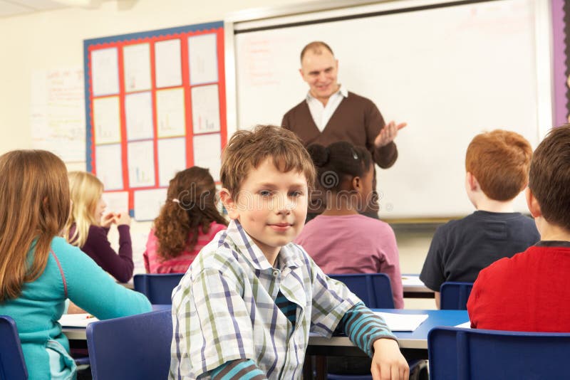 Schoolchildren Studying In Classroom With Teacher smiling at camera. Smiling asking stock images, royalty-free photos and pictures
