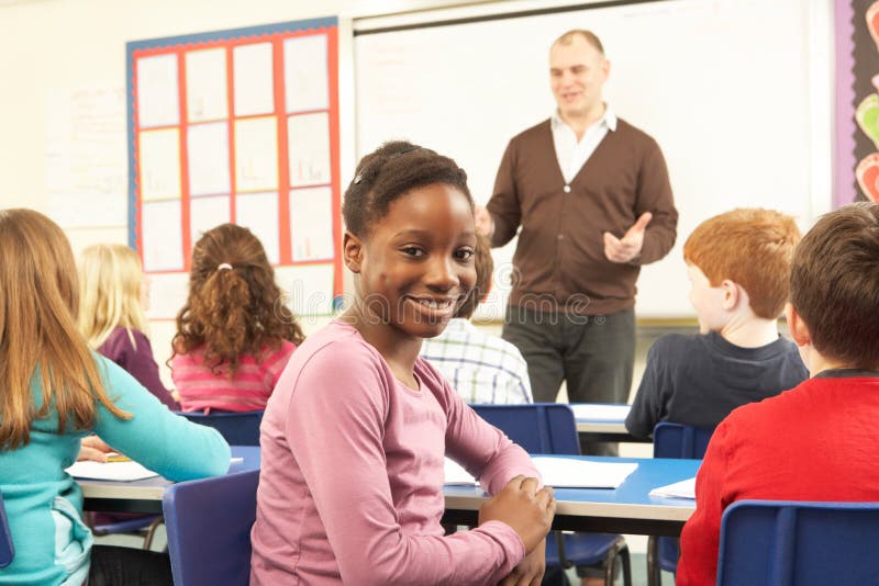 Schoolchildren Studying In Classroom With Teacher smiling at camera. Smiling asking stock images, royalty-free photos and pictures
