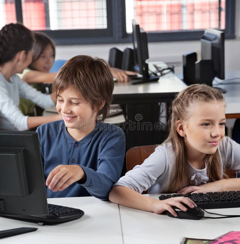 Schoolchildren Using Computer At Desk royalty free stock photos Schoolchildren Using Computer At Desk royalty free stock photos