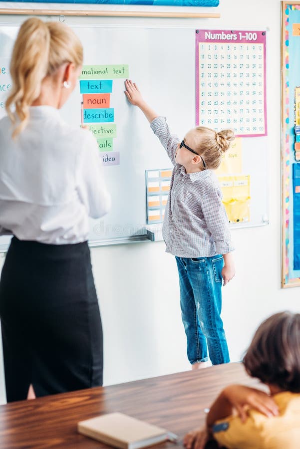 Teacher Looking at Adorable Schoolgirl Answering Next To Whiteboard ...