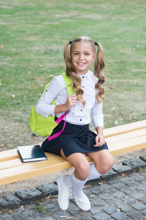 Schoolgirl cute child with backpack relax outdoors, formal education concept royalty free stock photography