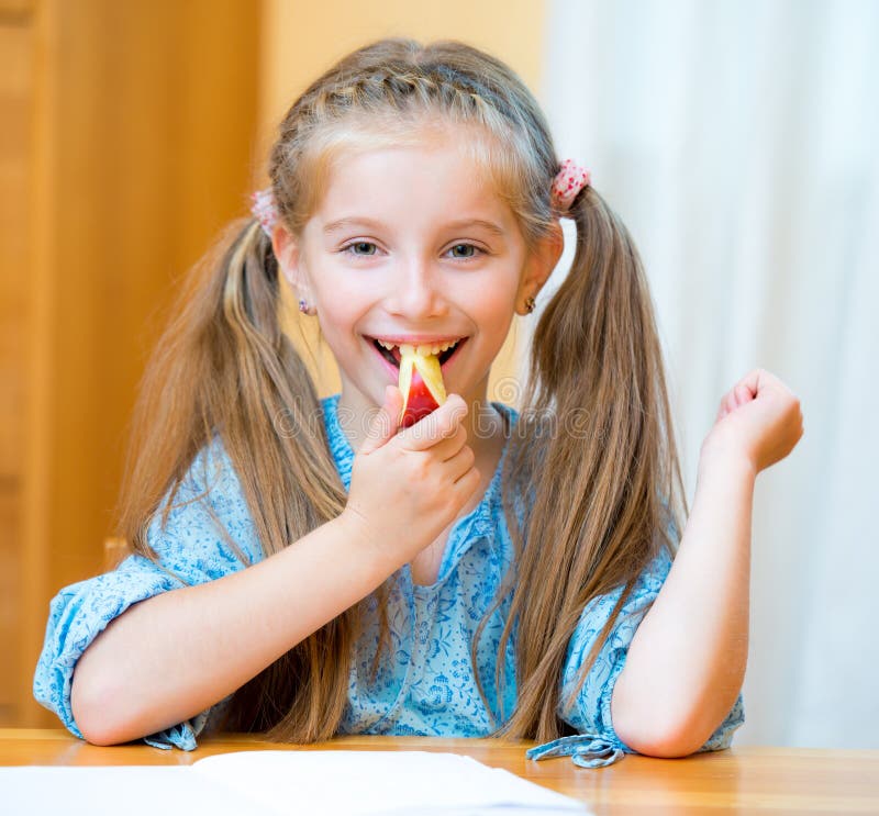 Schoolgirl eating apple stock image