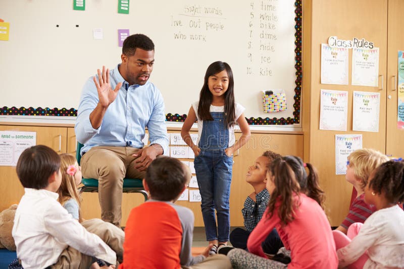 Schoolgirl at front of elementary class with teacher