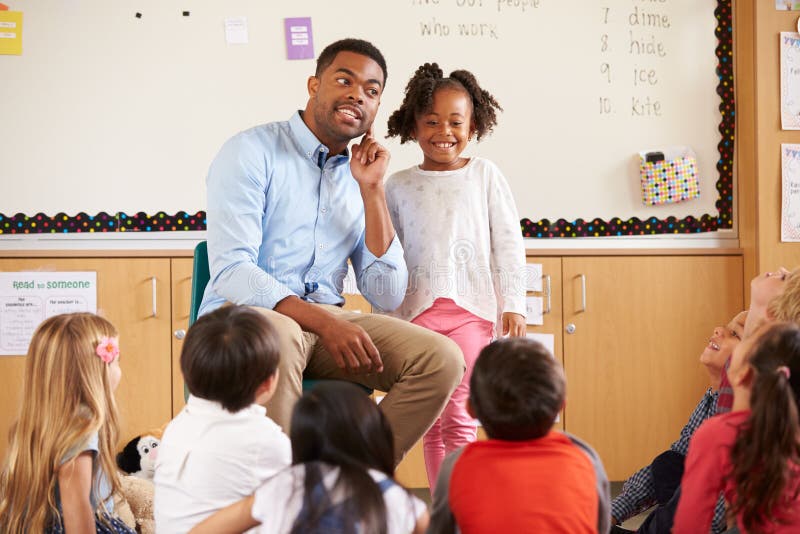 Schoolgirl at the front of elementary class with teacher