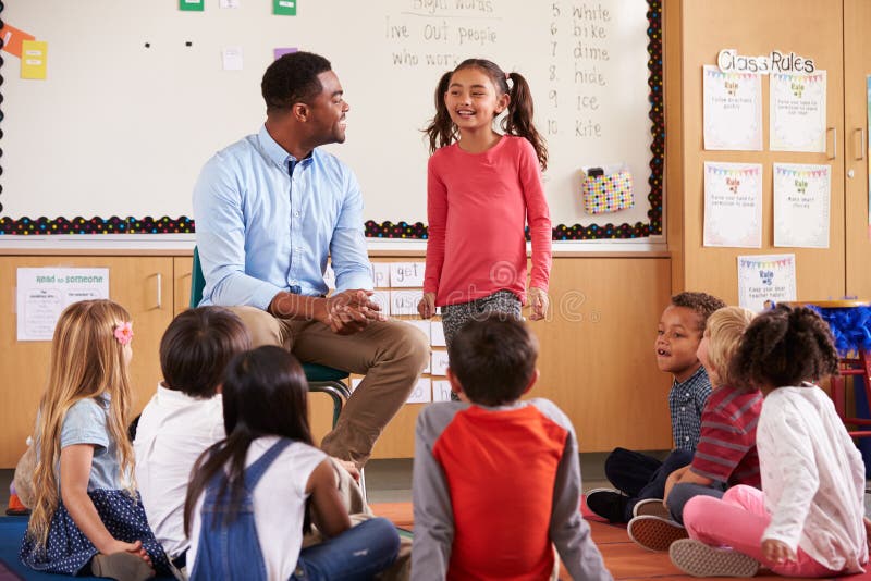 Schoolgirl at the front of elementary class with teacher