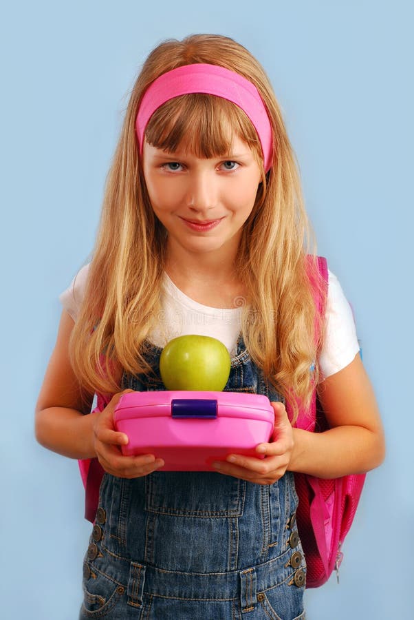 Schoolgirl with lunch box and apple royalty free stock photos
