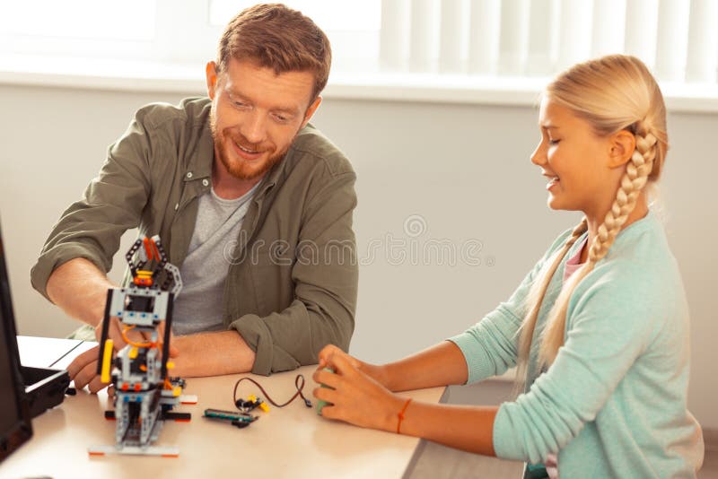 Schoolgirl showing the teacher her science project. stock images
