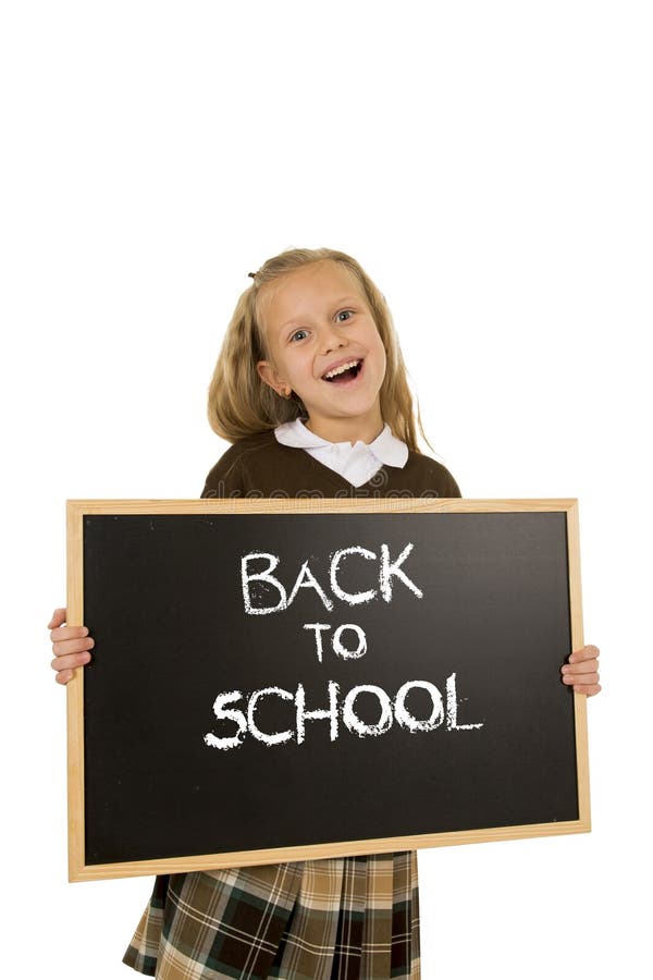 Schoolgirl smiling happy holding and showing small blackboard with text back to school