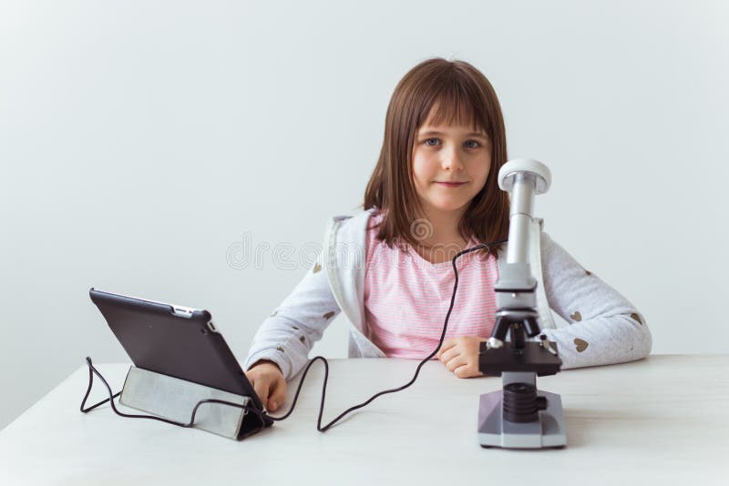 Schoolgirl Using Microscope in Science Class. Technologies, Lessons and