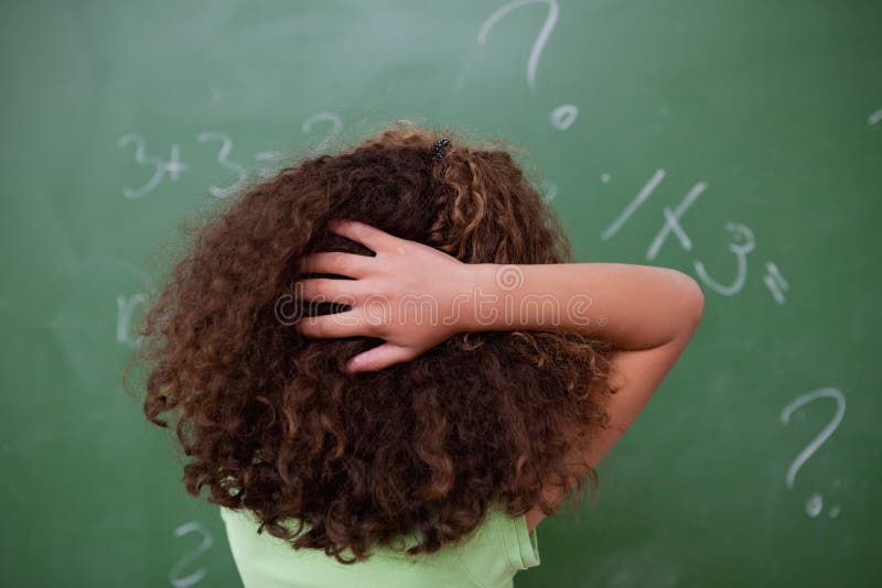Schoolgirlen som är tänkande om algebra, fördriver skrapa baksidaen av H