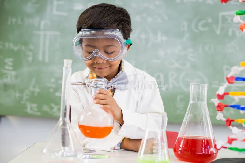 Schooljongen die een chemisch experiment in laboratorium doen stock foto Schooljongen die een chemisch experiment in laboratorium doen stock foto