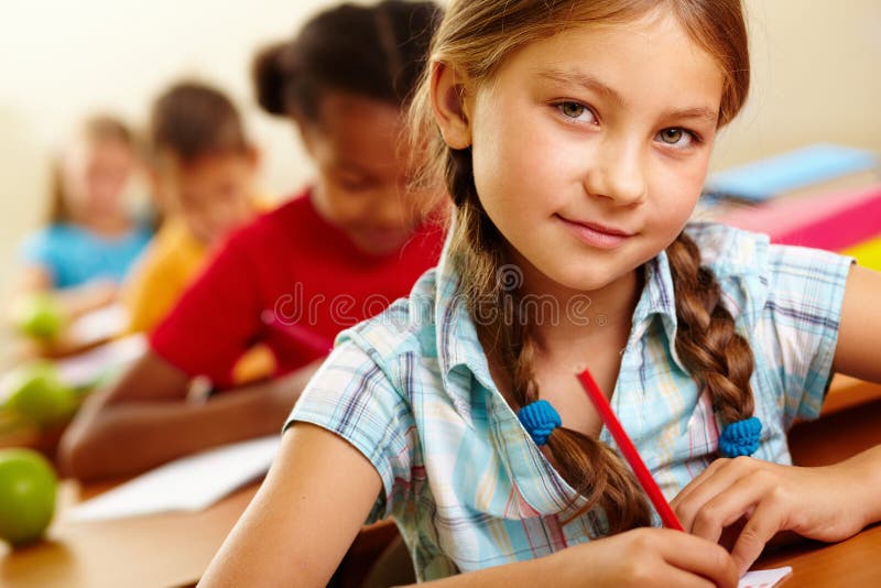 Portrait of lovely girl drawing in copybook and looking at camera. Portrait of lovely girl drawing in copybook and looking at camera