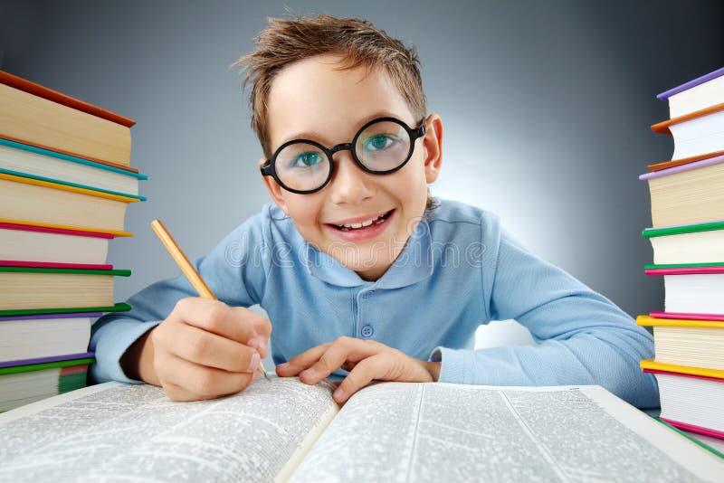 Portrait of cute lad in eyeglasses making notes in book during reading. Portrait of cute lad in eyeglasses making notes in book during reading