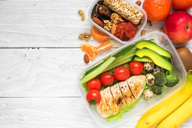 Schoolmaaltijddozen met kip, avocado, eieren en verse groenten, noten en vruchten op witte houten achtergrond stock afbeeldingen Schoolmaaltijddozen met kip, avocado, eieren en verse groenten, noten en vruchten op witte houten achtergrond stock afbeeldingen