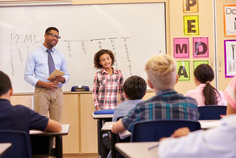 Schoolmeisje die aan haar basisschoolklasgenoten voorstellen stock afbeeldingen Schoolmeisje die aan haar basisschoolklasgenoten voorstellen stock afbeeldingen