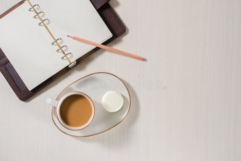 Schoon notitieboekje, kop van koffie en kleurrijke macaron op grijze Desktopmening stock afbeelding Schoon notitieboekje, kop van koffie en kleurrijke macaron op grijze Desktopmening stock afbeelding