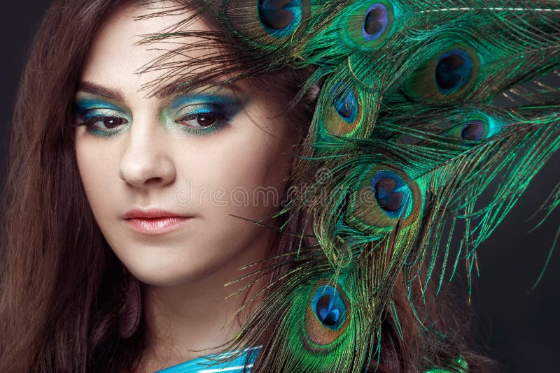 Schoonheidsportret die van mooi meisje de ogen behandelen met pauwveer Creatieve make-up peafowl veren aantrekkelijk royalty-vrije stock foto's Schoonheidsportret die van mooi meisje de ogen behandelen met pauwveer Creatieve make-up peafowl veren aantrekkelijk royalty-vrije stock foto's