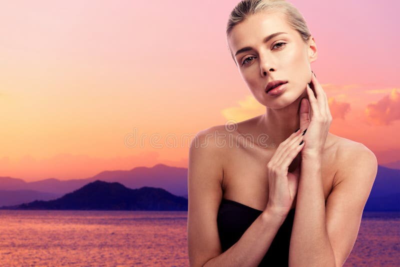 Schoonheidsportret van een jonge mooie vrouw bij zonsondergang Zwart zwempak en blondehaar Bergen en overzees op de achtergrond stock foto Schoonheidsportret van een jonge mooie vrouw bij zonsondergang Zwart zwempak en blondehaar Bergen en overzees op de achtergrond stock foto