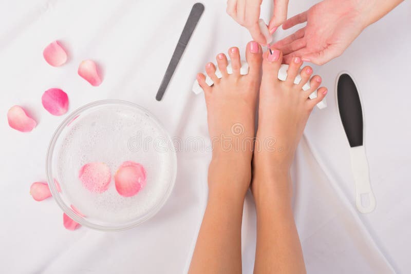 Schoonheidsspecialist het schilderen de teennagels van de vrouw royalty-vrije stock afbeeldingen Schoonheidsspecialist het schilderen de teennagels van de vrouw royalty-vrije stock afbeeldingen