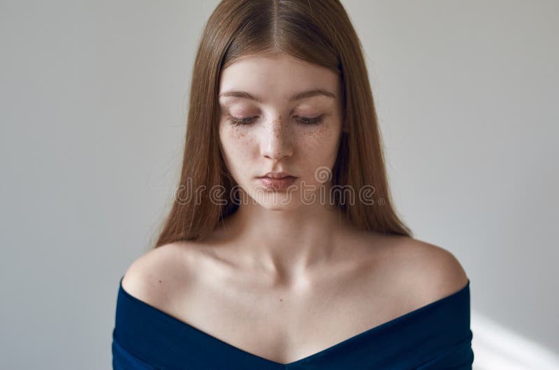 Schoonheidsthema: portret van een mooi jong meisje met sproeten op haar gezicht en het dragen van een blauwe kleding op een witte stock foto's Schoonheidsthema: portret van een mooi jong meisje met sproeten op haar gezicht en het dragen van een blauwe kleding op een witte stock foto's