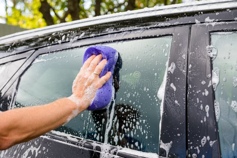 Schoonmakende auto die Hoge drukwater gebruiken Mens die zijn auto wassen onder hoge drukwater in de dienst Arbeiderswas royalty-vrije stock afbeelding Schoonmakende auto die Hoge drukwater gebruiken Mens die zijn auto wassen onder hoge drukwater in de dienst Arbeiderswas royalty-vrije stock afbeelding
