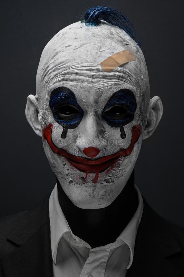 Schrecklicher Clown und Halloween-Thema: Verrückter schrecklicher blauer Clown im schwarzen Anzug lokalisiert auf einem dunklen H lizenzfreie stockbilder Schrecklicher Clown und Halloween-Thema: Verrückter schrecklicher blauer Clown im schwarzen Anzug lokalisiert auf einem dunklen H lizenzfreie stockbilder