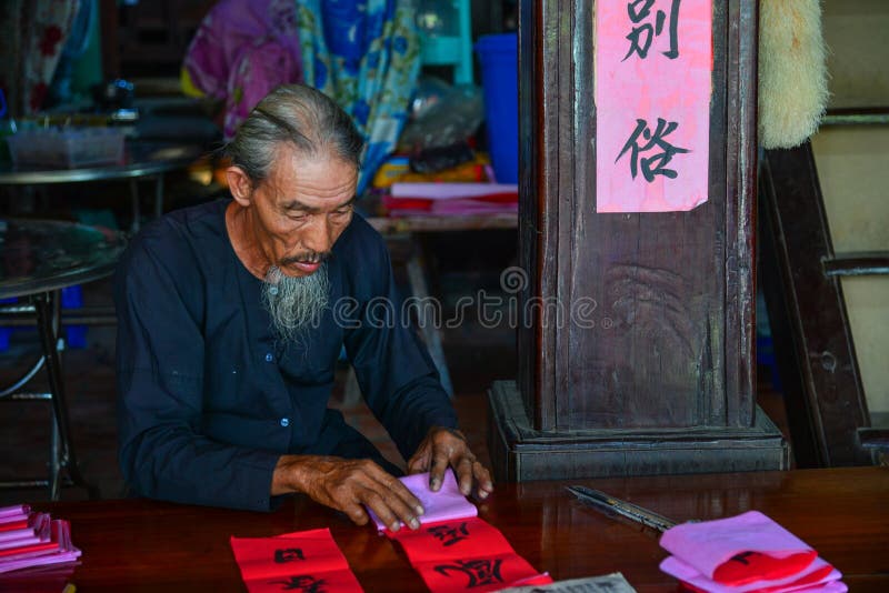 Schreiben der chinesischen Kalligraphie auf rotes Papier lizenzfreie stockfotografie Schreiben der chinesischen Kalligraphie auf rotes Papier lizenzfreie stockfotografie